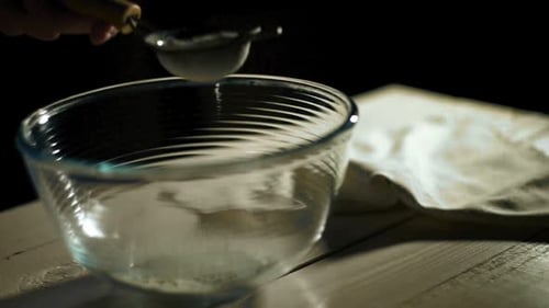 Man Hand Pours Flour Through Sieve Into Glass Bowl. Close Up Sifting