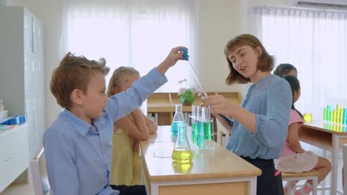 Adorable student learn with teacher in classroom at elementary school.