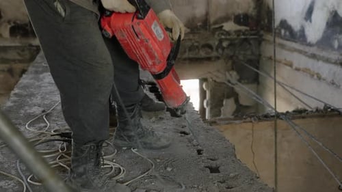 Adults Demolishing Concrete with Jackhammers Indoors