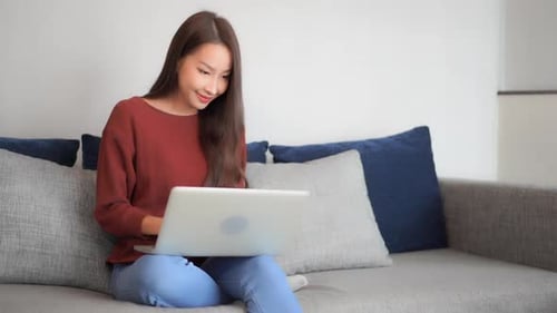 Excited Young Adult Woman Working on Laptop at Home