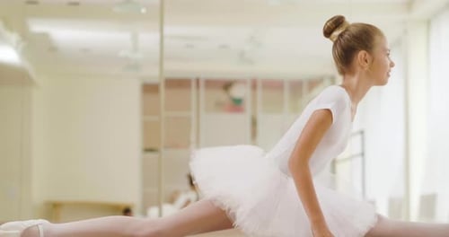 Portrait of a beautiful girl, in a dance school wearing a white tutu, she trains alone to learn ne