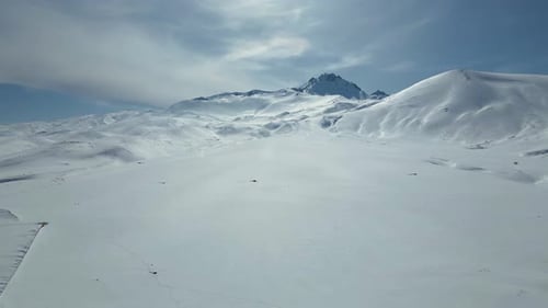 Luftaufnahme der kurvenreichen Autobahn durch schneebedeckte Berge