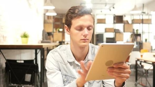 Young Man Using Tablet in Office