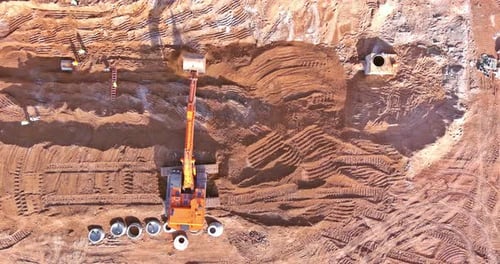 Aerial View of Excavator Moving Dirt on Construction Site