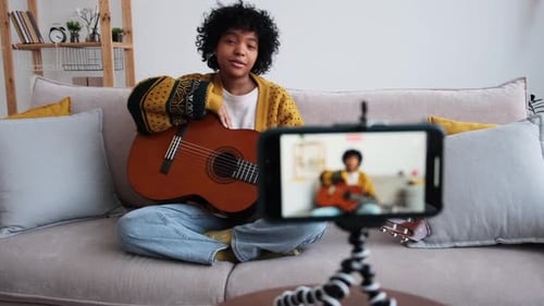 Young Adult Plays Guitar and Records Video