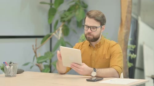 Man Using Tablet Device at Desk Indoors