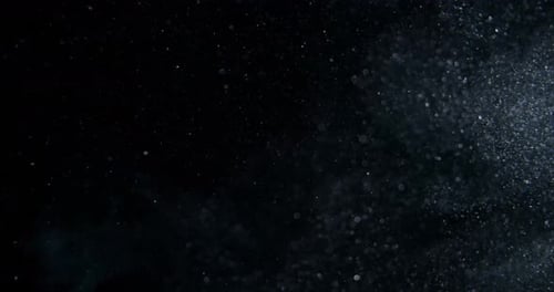 Strudel aus gemischten Staubpartikeln, Mehl, Trümmern, die auf schwarzem Hintergrund fliegen