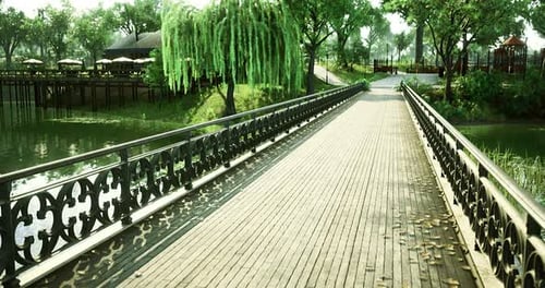 Serene Park Bridge Over Calm Water Surrounded By Lush Greenery