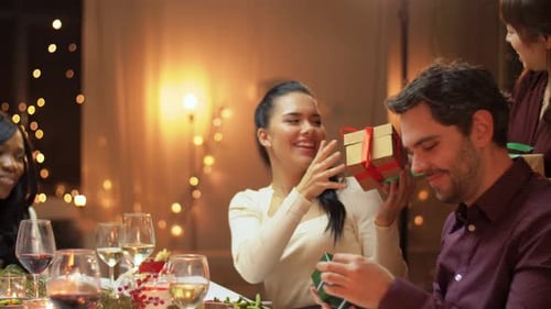 Friends Giving Gifts at Cozy Holiday Dinner Party