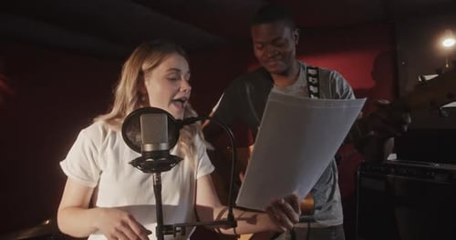 Creating Music in Studio Multiracial Music Group Singer Girl Singing Into a Microphone Dancing and