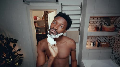 Man Applies Shaving Cream in Bathroom