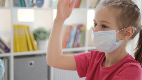 Child With Raised Hand Wearing Medical Face Mask