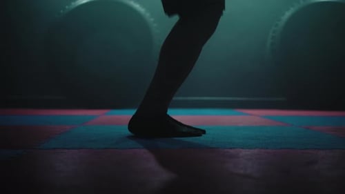 Adult Barefoot Jumping Jacks in Dark Gym