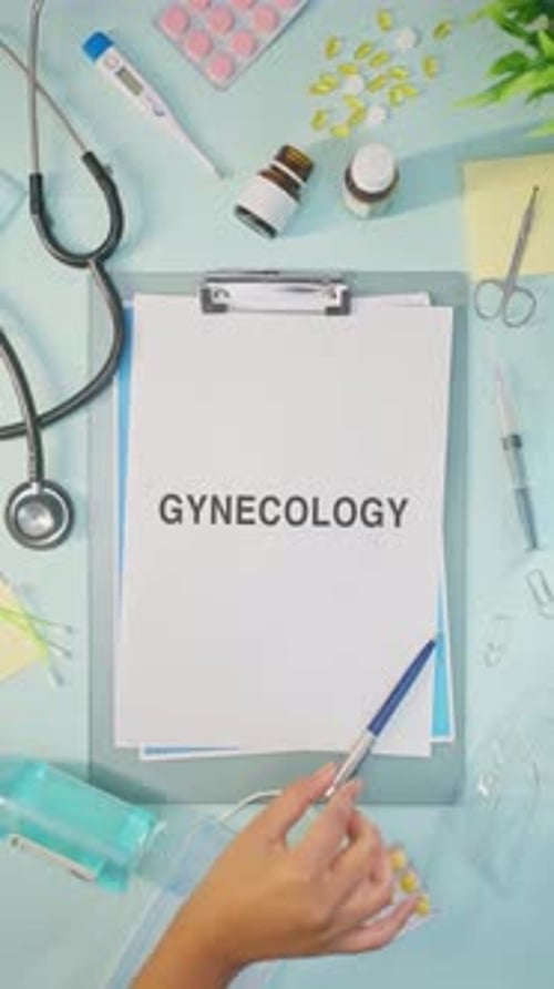 Gynecology Tools on Desk with Clipboard and Pills