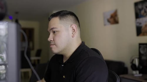 superenge Aufnahme eines jungen Latino-Mannes mit weißer Haut, der an einem Desktop-Computer arbeitet