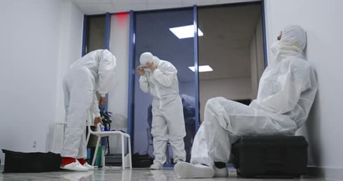 People Wearing White Protective Clothing in a Room