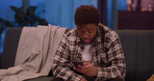 Indoor Portrait of African American Handsome Man College Student with Phone Smiling Positively to
