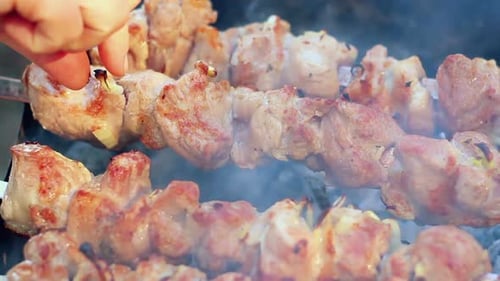 Delicious skewers of meat cooking over hot grill