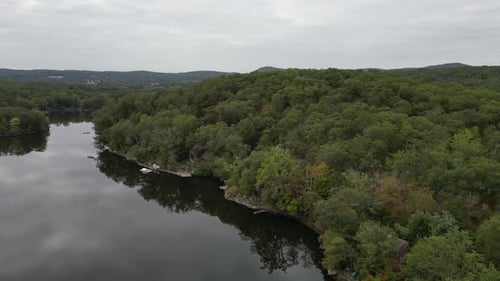 Beautiful aerial footage showing a tranquil river snaking through a vast, dense forest under a