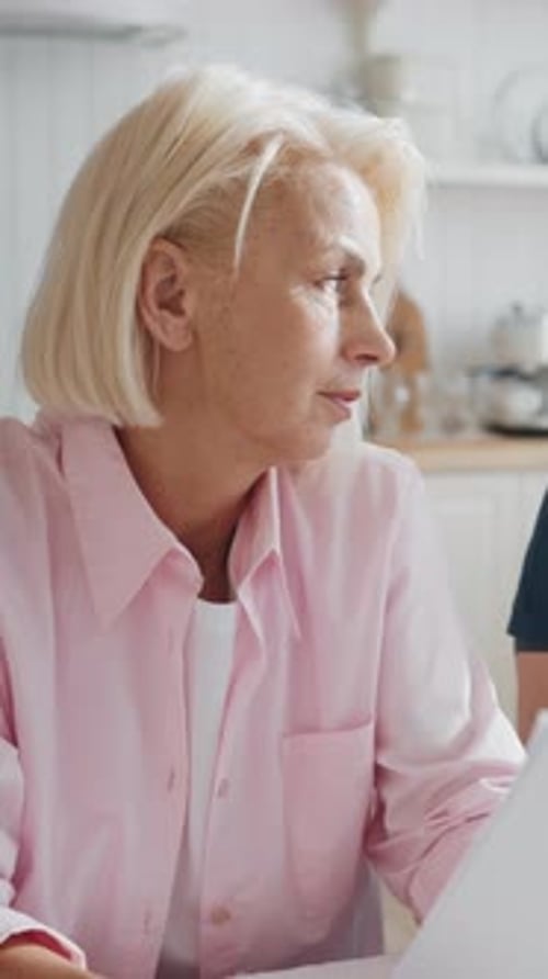 Senior Woman Reviewing Documents with Adult