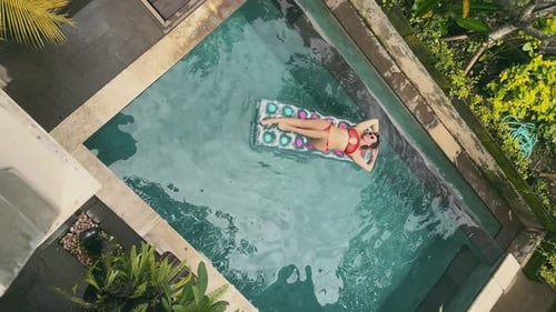 Top View Portrait of Young Woman Lying on an Inflatable Air Mattress