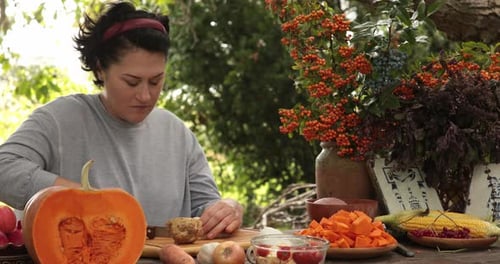 Woman Prepares Vegetables on Wooden Table Outside