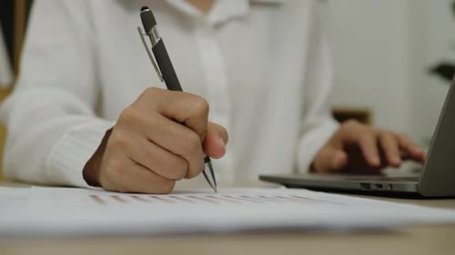 close up hand holding pen and writing document work at home office