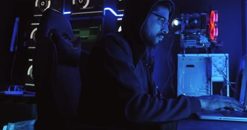 Um hacker masculino está usando um computador para hackear dados e exigir resgate das vítimas.