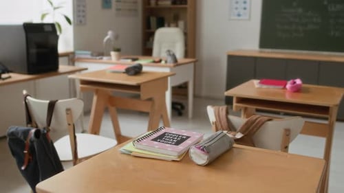 Close up of Notebook and Pencil Case on Wooden Desk in Modern Classroom