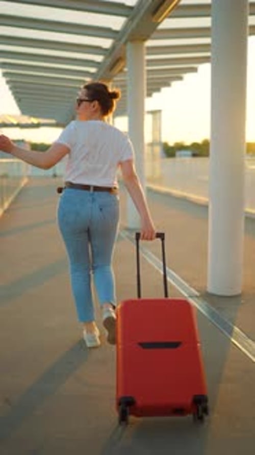 Mulher caucasiana puxando uma mala e chegando atrasada para o voo. Câmera lenta