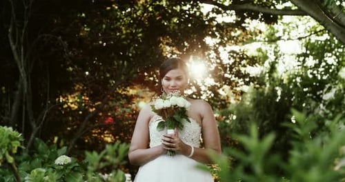 Beautiful Bride Holding Flowers in Garden