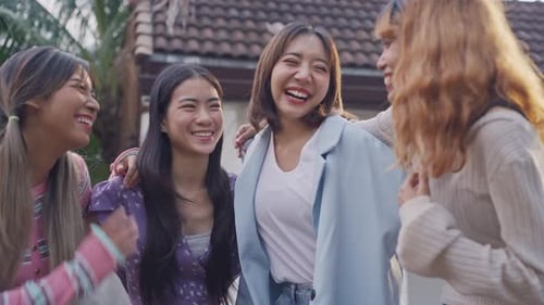 Grupo de amigas ao ar livre juntas na frente de sua casa.