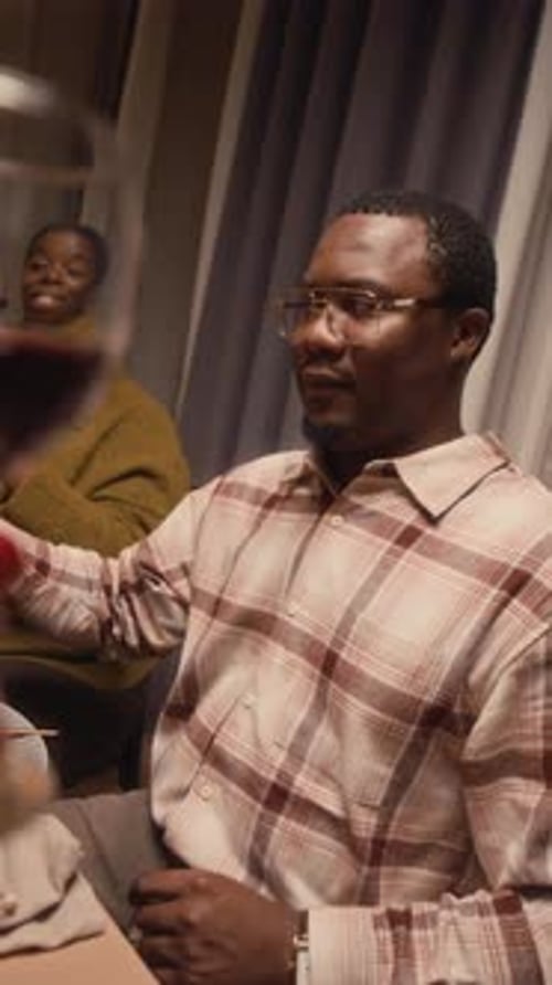 Des personnes multiethniques tintent des verres pour célébrer Thanksgiving à la maison