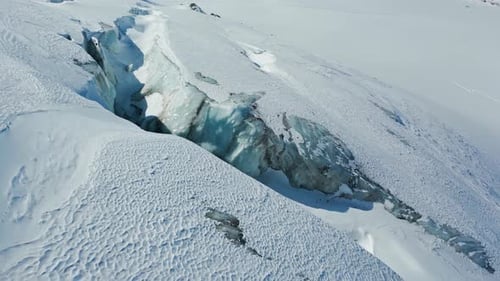 Aerial View of Glacial Crevasse in Snow Mountains