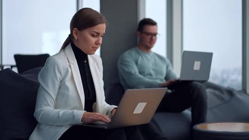 Professionals Working on Laptops in a Modern Office