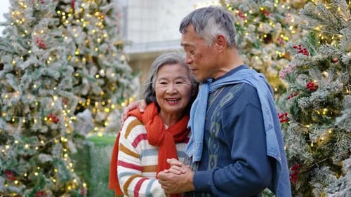 Senior Couple Dancing Between Christmas Trees in Urban Setting