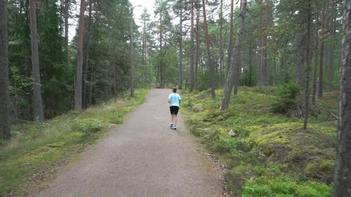 Happy Athletic Woman Running Through the Park