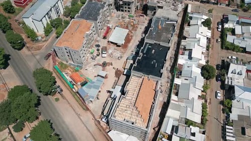 Captura reveladora mirando hacia abajo sobre una obra en construcción activa con grúas y dejando al descubierto la estructura del edificio