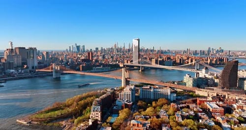 The East River with the Brooklyn and Manhattan Bridges above it. A yacht ferry boat by the river