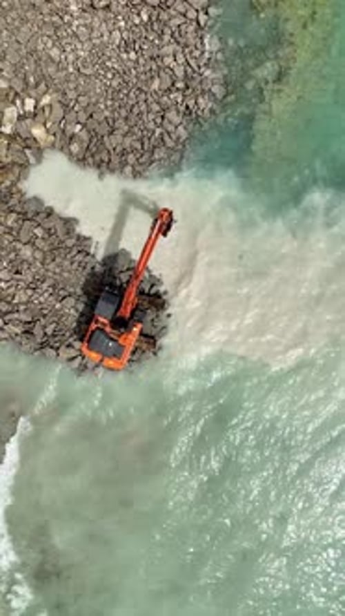 Vídeo vertical de renovación costera: vista aérea de la remodelación de la playa con una enorme excavadora