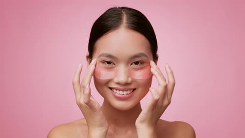 Woman Smiling and Applying Beauty Eye Patches