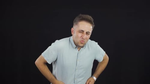 Man Experiencing Stomach Pain Against Black Background