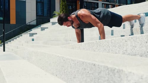Strong Man Exercising with Push-ups on Urban Stairs
