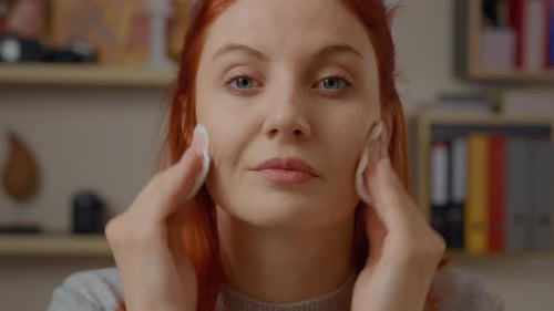 Redhead Woman Removing Makeup with Cotton Pads