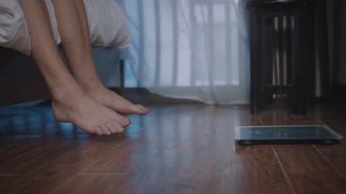 Bare Feet Get Out of Bed Next to Scale