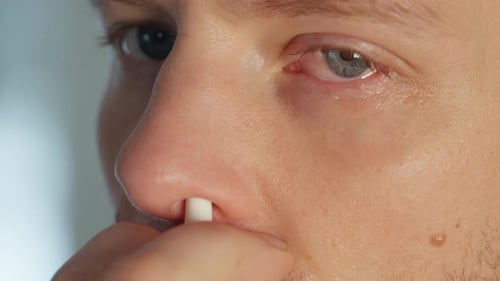 Un homme atténue ses symptômes avec un spray nasal, gros plan à 60 images par seconde