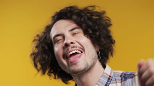 Happy Man Dancing Enthusiastically on Yellow Background
