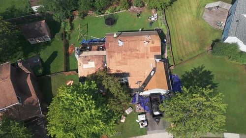 Roofers Installing a New Roof on an Residential Building Wide Drone Top Down View