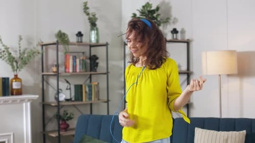 Woman Dancing to Music with Headphones at Home
