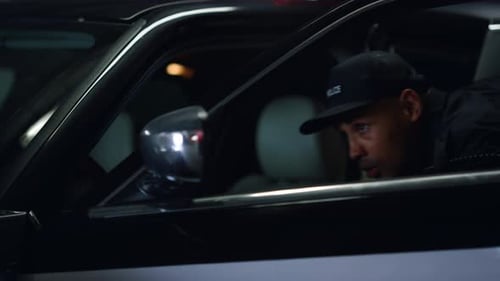 Police Officer in Car at Night Holding Gun